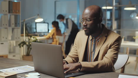 Hombre-De-Negocios-Afroamericano-Trabajando-En-Una-Laptop-Tarde-En-La-Oficina